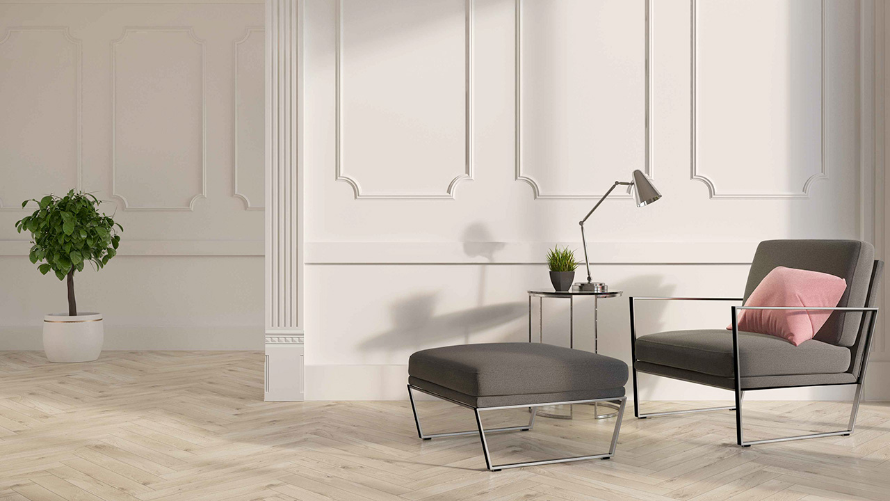 Living con pareti crema e poltroncina con poggiapiedi grigio fumo